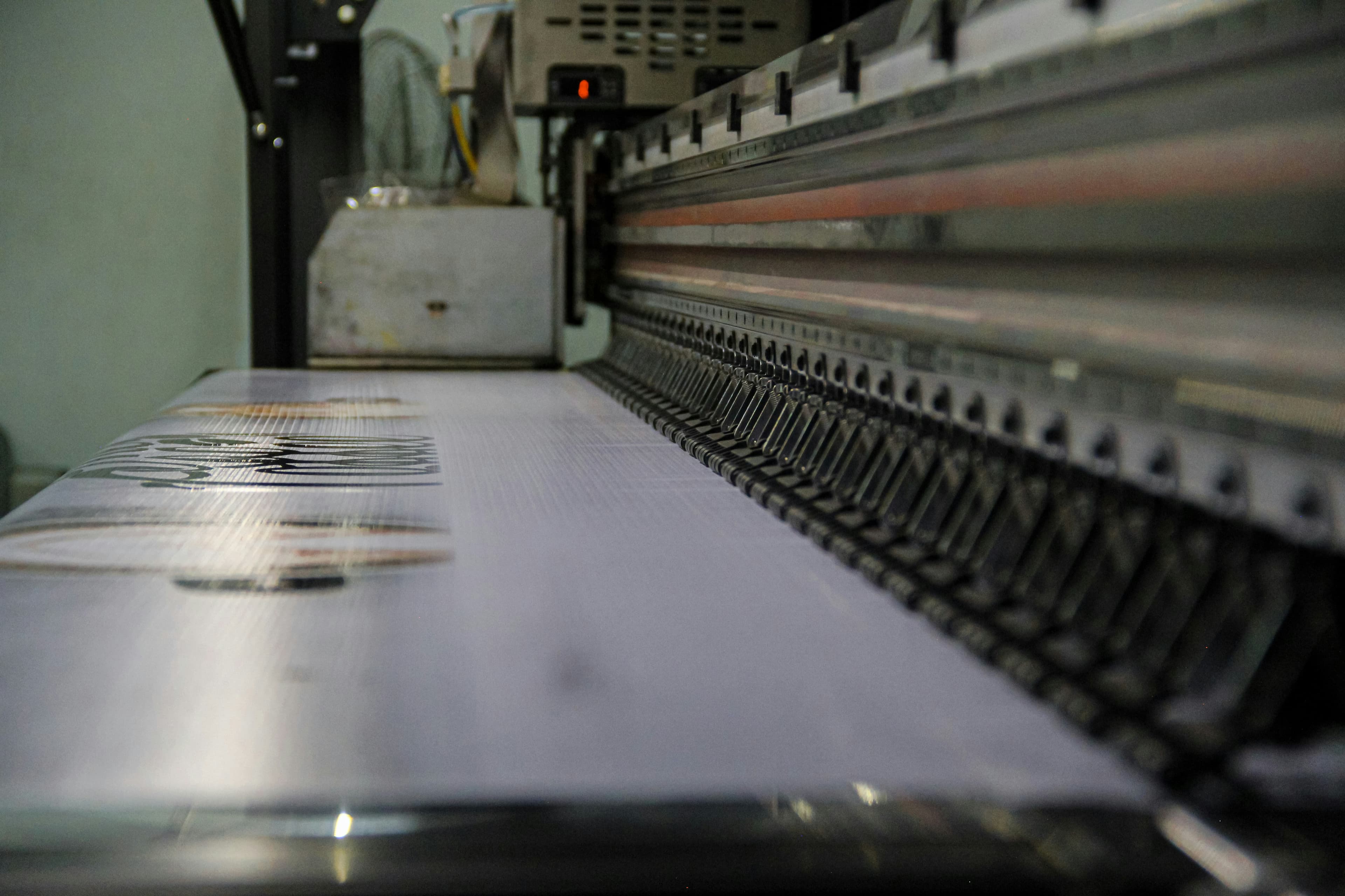 Industrielle Druckmaschine verarbeitet ein bedrucktes Material in einer Produktionsumgebung.